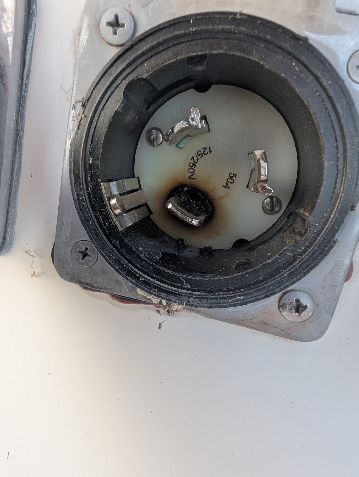Burned contact and scorched surrounding material on the original vessel shore-power inlet